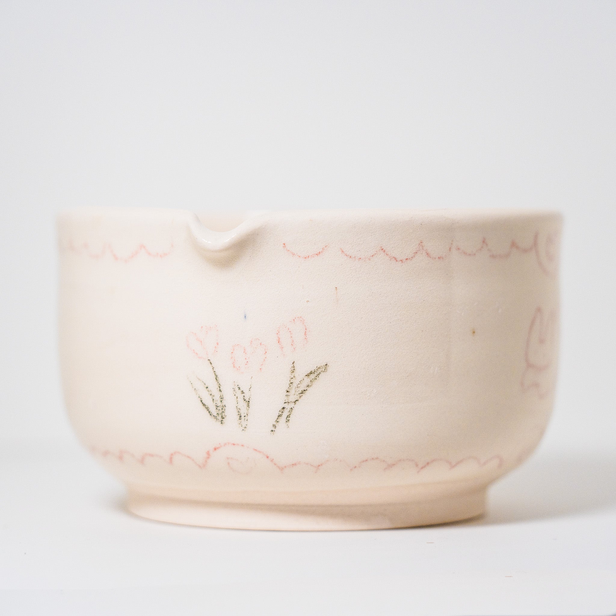 Ceramic matcha bowl with floral design on a white background
