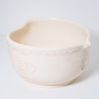 Ceramic matcha bowl with floral design on a white background