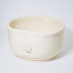 Ceramic matcha bowl with floral design on a white background