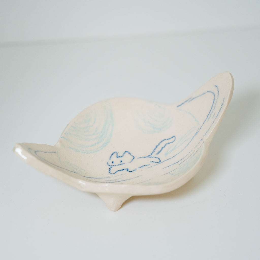 Ceramic planet-shaped dish with blue detailing on a light gray background
