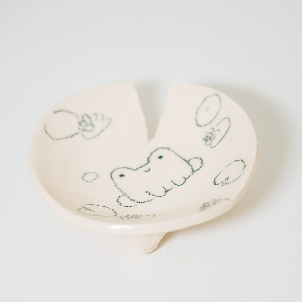 Heart-shaped ceramic plate with hand-drawn designs on a white background
