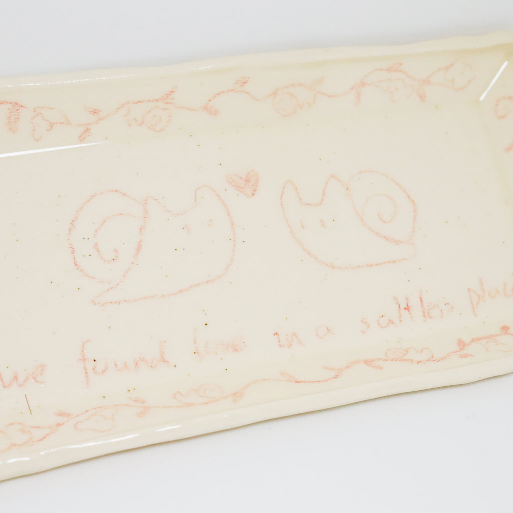 Decorative plate with snail illustrations and text on a white background