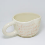 White mug with red text on a white background