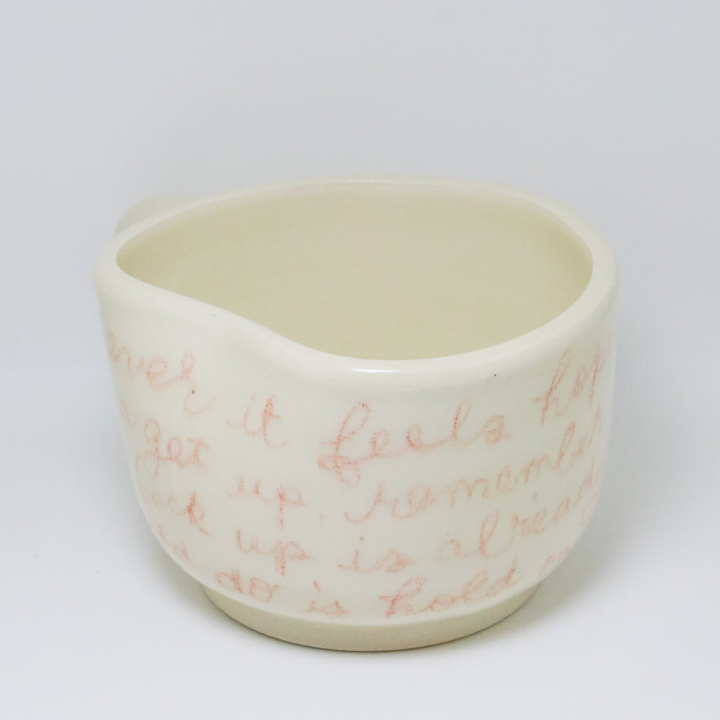 White ceramic cup with red text on a white background