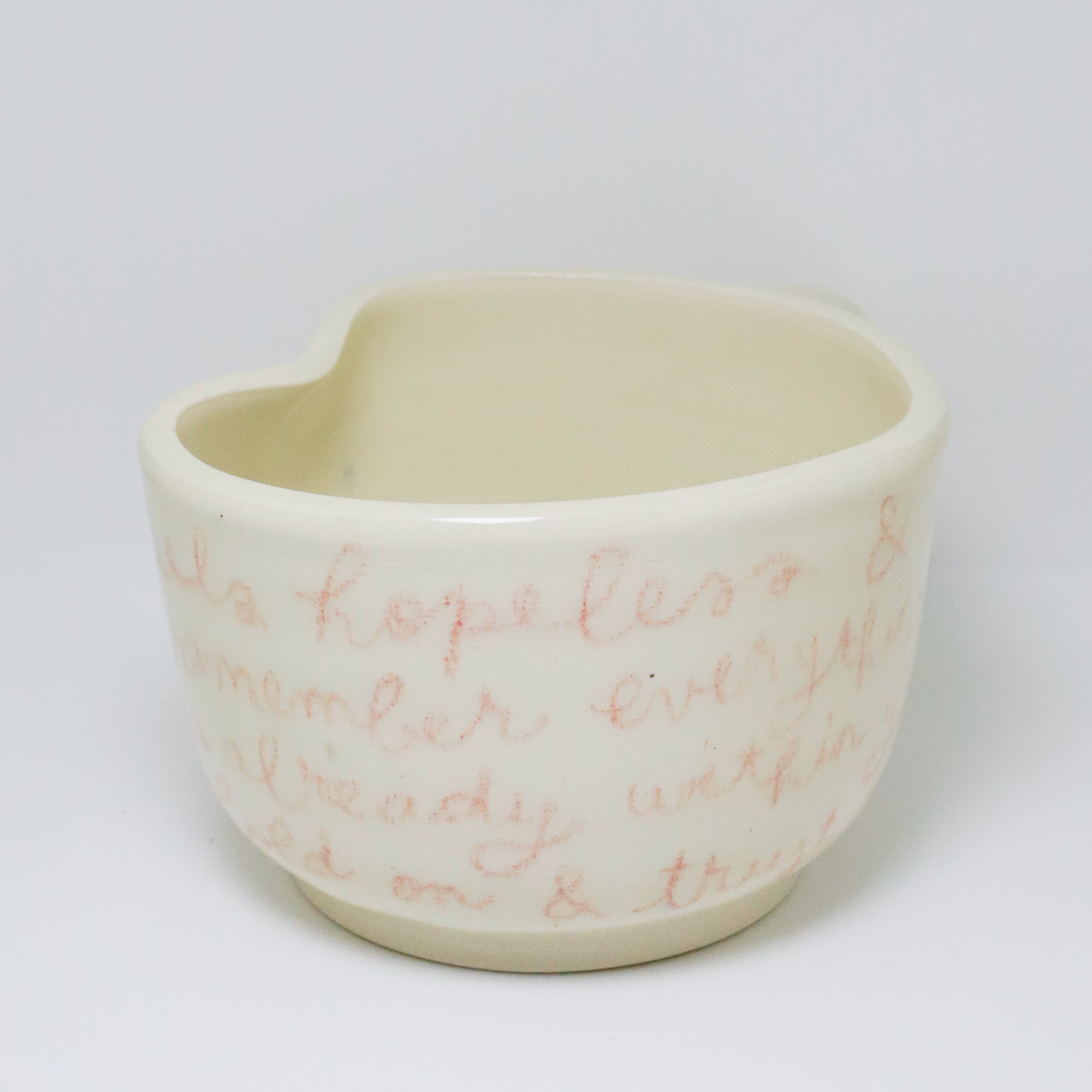 White ceramic mug with pink text on a white background