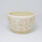 Ceramic cup with red line drawings on a white background