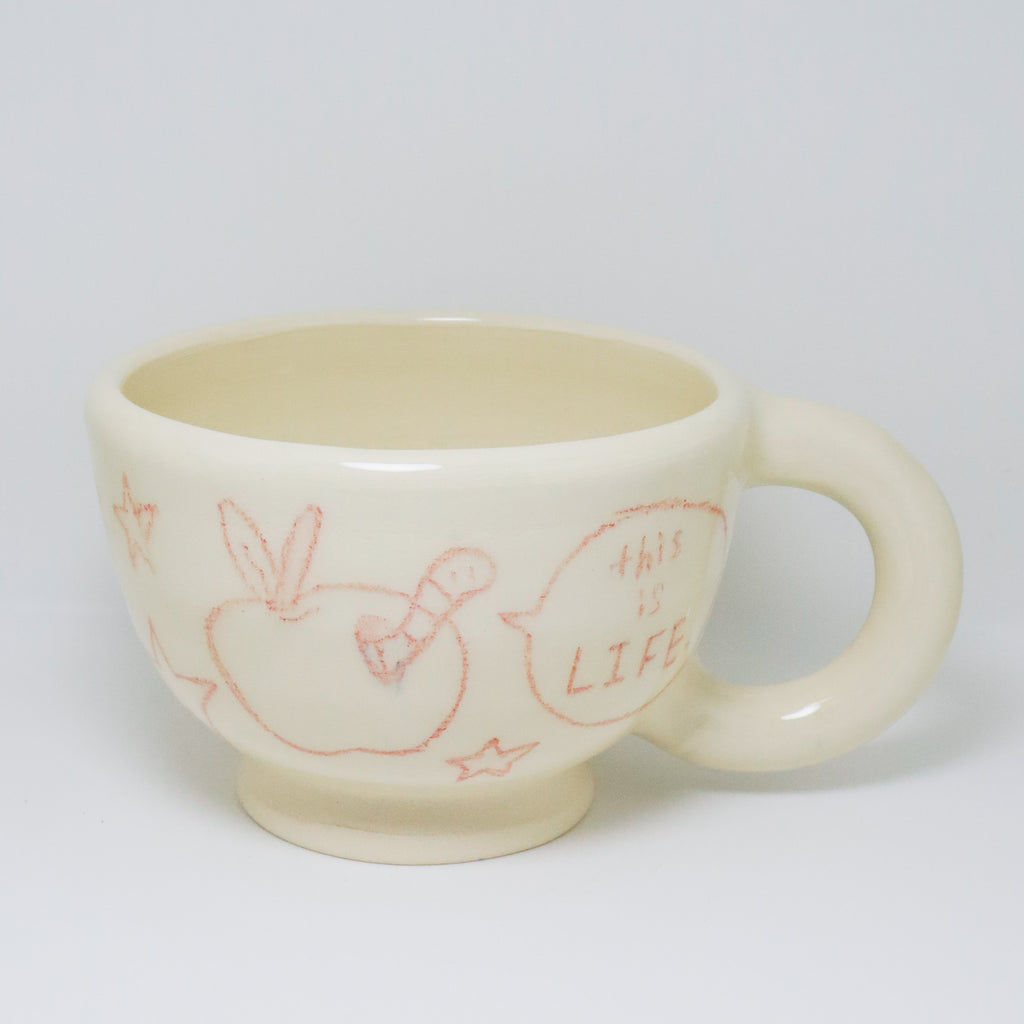 White ceramic mug with red illustrations and text on a white background