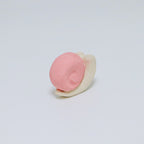 Pink and white ceramic snail on a light gray background