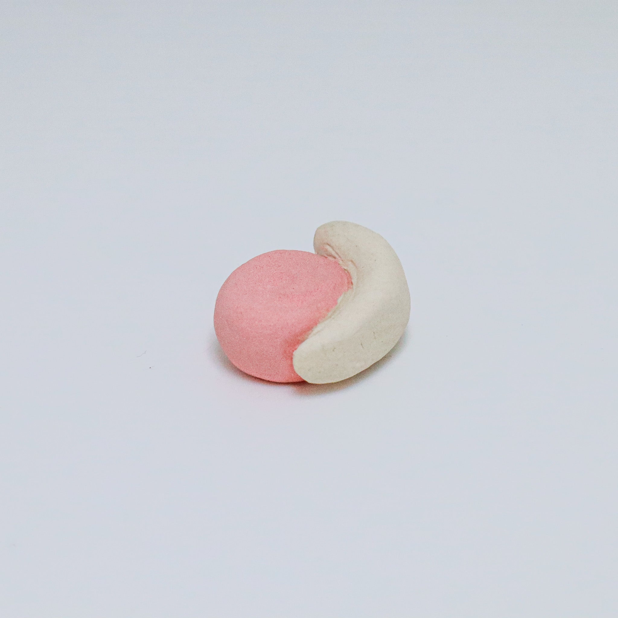 Pink and beige ceramic snail on a light gray background