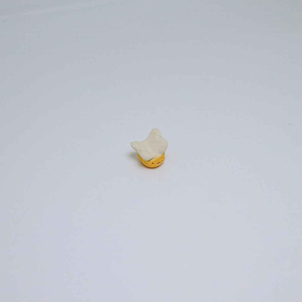 Small ceramic bee on a light gray background