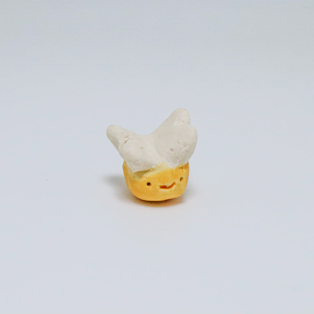 Small figurine of a bee with a smiley face on a light gray background