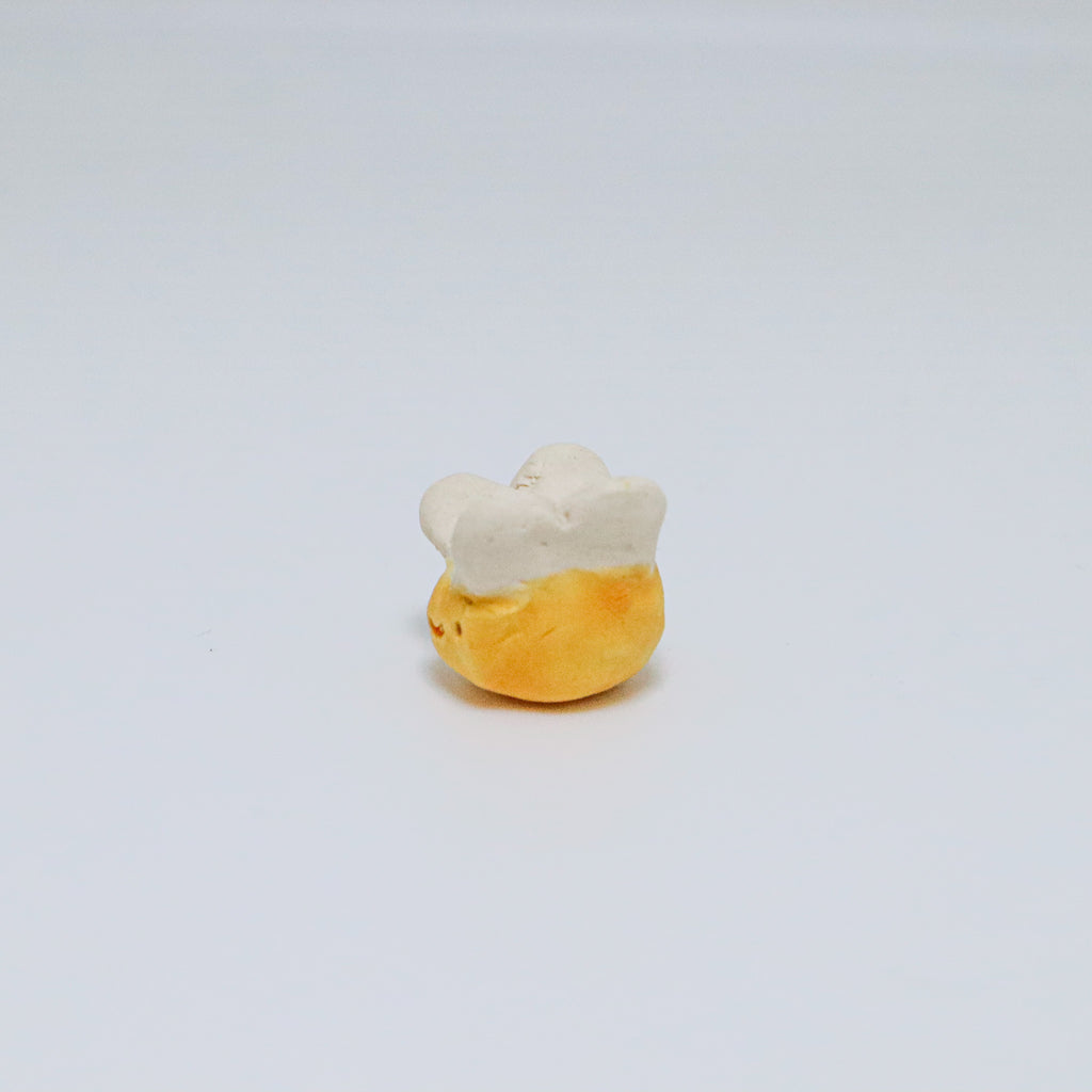 Small ceramic bee on a light gray background