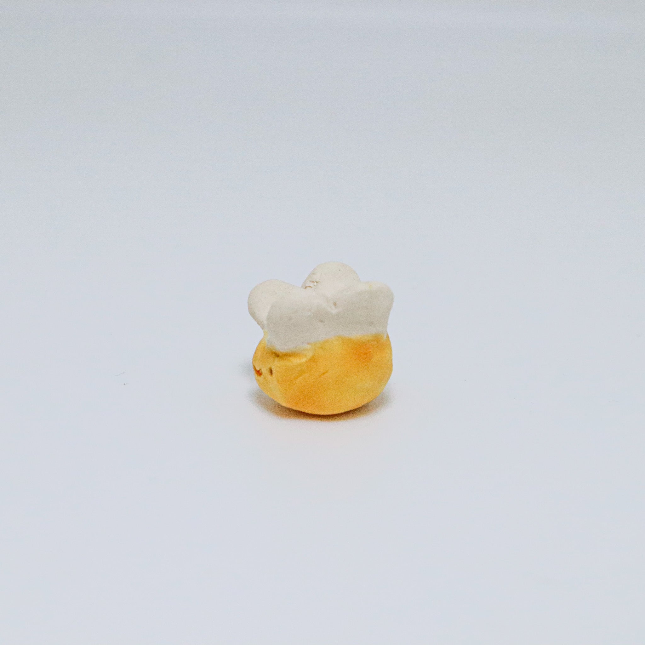 Small ceramic bee on a light gray background