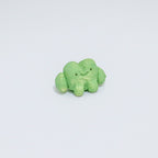 Green ceramic frog on a light gray background
