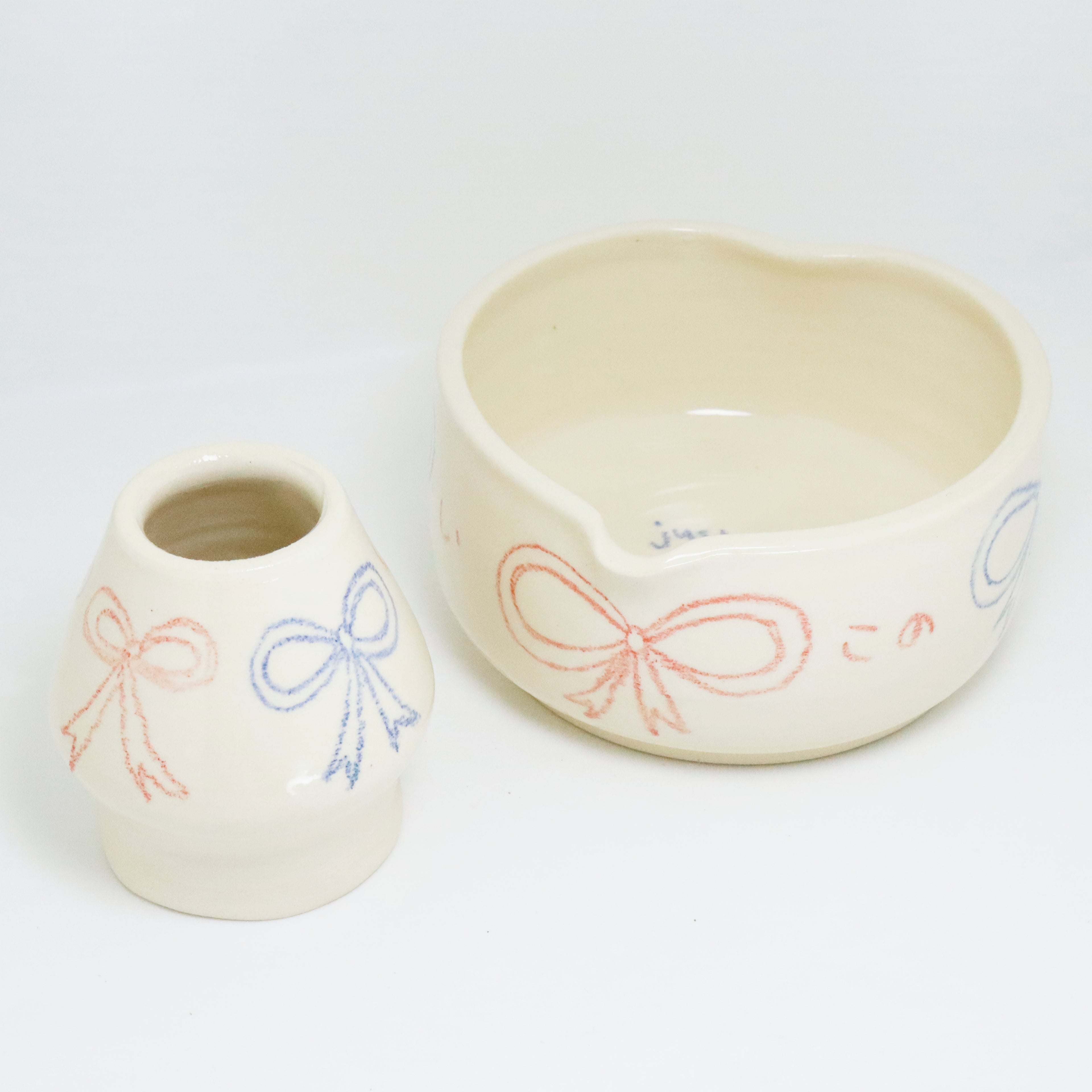 Two ceramic bowls with bow designs on a white background