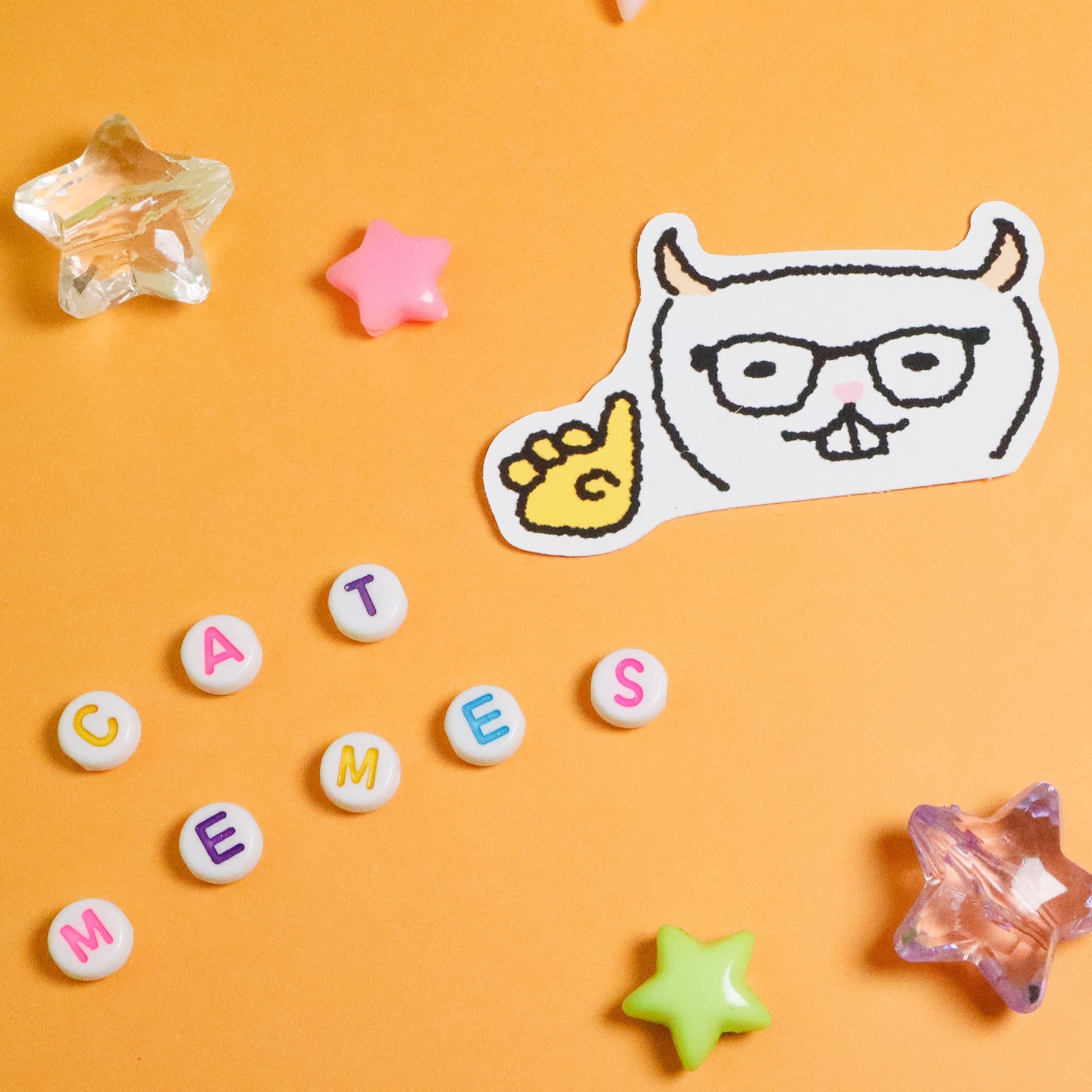 Sticker of a cat with glasses and colorful letters on an orange background
